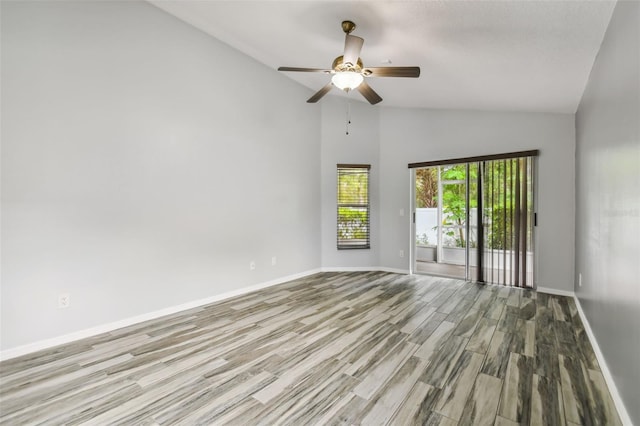 spare room with high vaulted ceiling, ceiling fan, baseboards, and wood finished floors