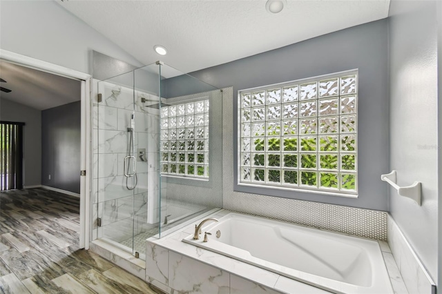 bathroom featuring vaulted ceiling, a stall shower, wood finished floors, and a bath