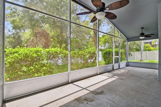 unfurnished sunroom with vaulted ceiling and a ceiling fan