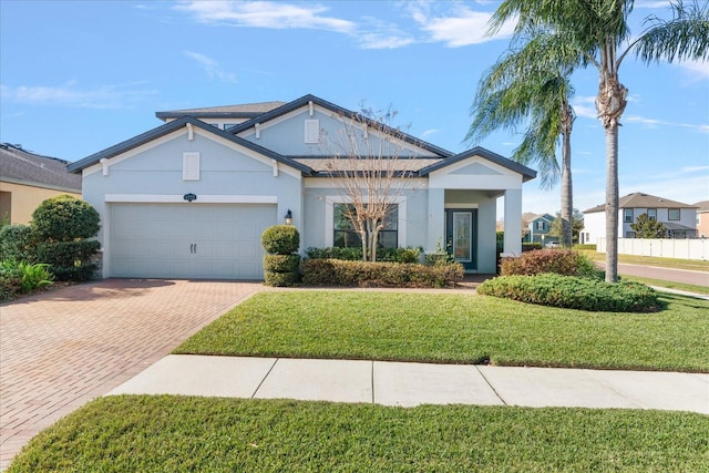 view of front facade featuring a garage, a front lawn, decorative driveway, and stucco siding