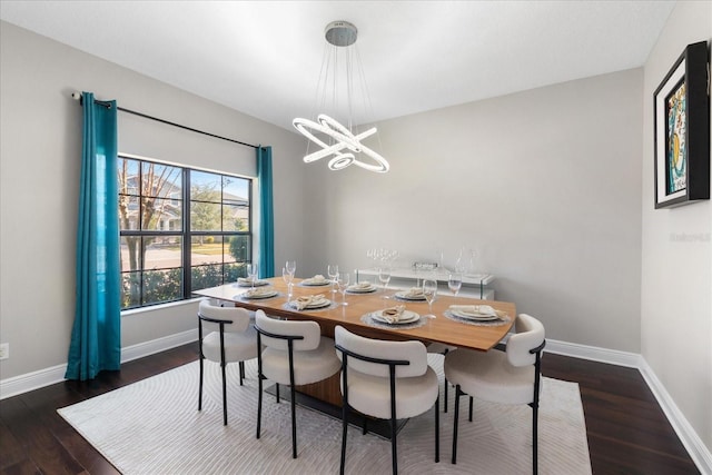 dining area with baseboards, a chandelier, and dark wood-style flooring