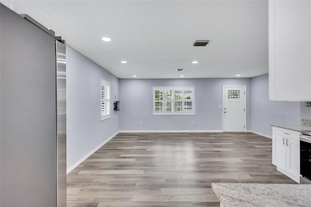 interior space featuring light wood-style flooring, visible vents, baseboards, and recessed lighting