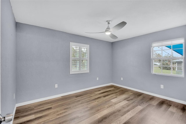 empty room featuring ceiling fan, wood finished floors, and baseboards