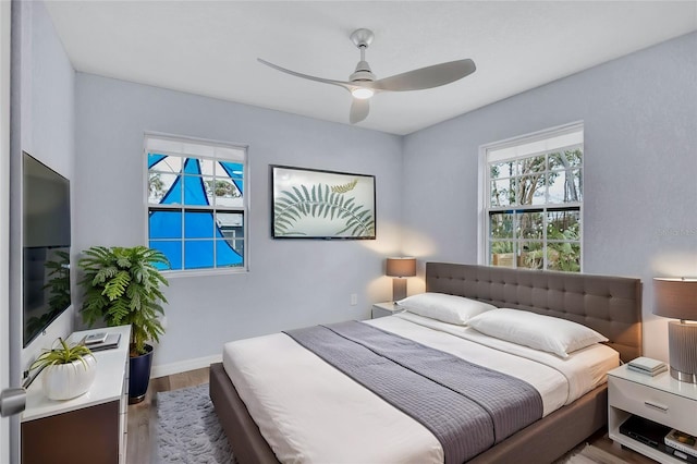 bedroom featuring wood finished floors, a ceiling fan, and baseboards