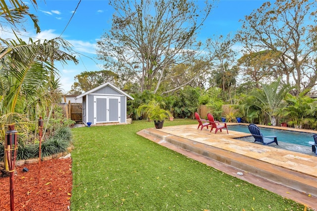 view of yard featuring a fenced in pool, a patio, a fenced backyard, an outdoor structure, and a shed