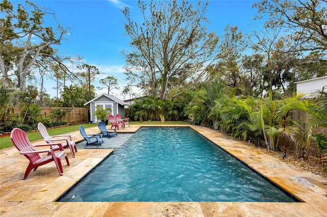 view of swimming pool featuring a patio, an outdoor structure, a fenced backyard, and a fenced in pool