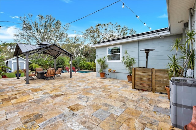 view of patio / terrace with an outbuilding, a gazebo, and a storage unit