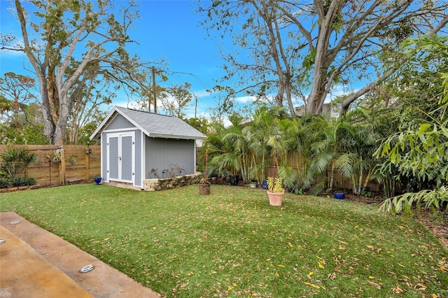 view of yard featuring an outbuilding, a fenced backyard, and a shed