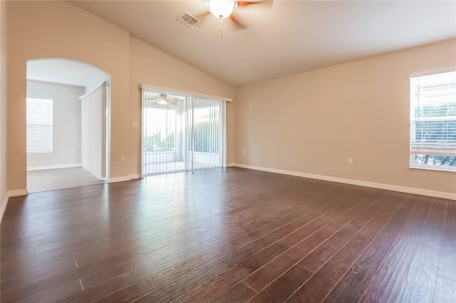 unfurnished room with plenty of natural light, ceiling fan, visible vents, and dark wood-type flooring