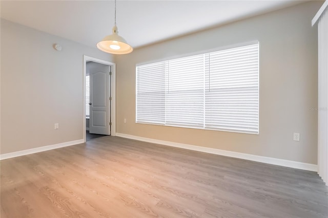 spare room featuring light wood-style flooring and baseboards