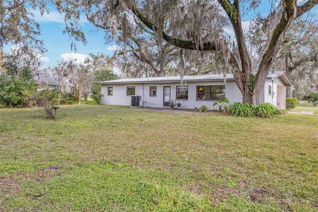 ranch-style house featuring metal roof, central AC unit, and a front yard