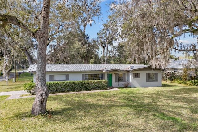 ranch-style house featuring a front yard and metal roof