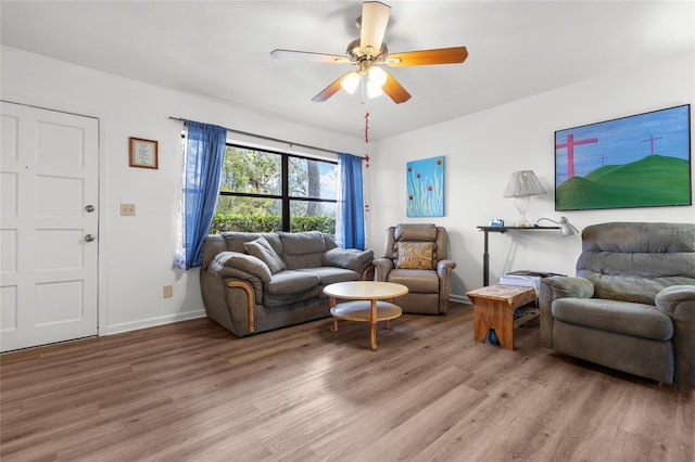 living area featuring light wood-style flooring, baseboards, and ceiling fan