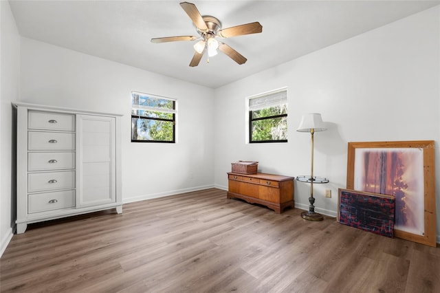 bedroom featuring wood finished floors, a ceiling fan, and baseboards