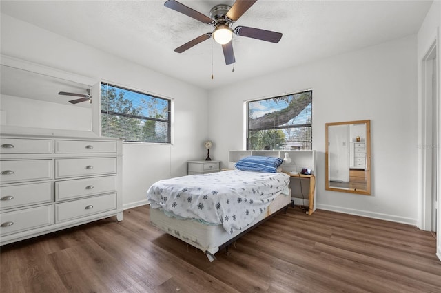 bedroom featuring dark wood-style floors, multiple windows, and baseboards