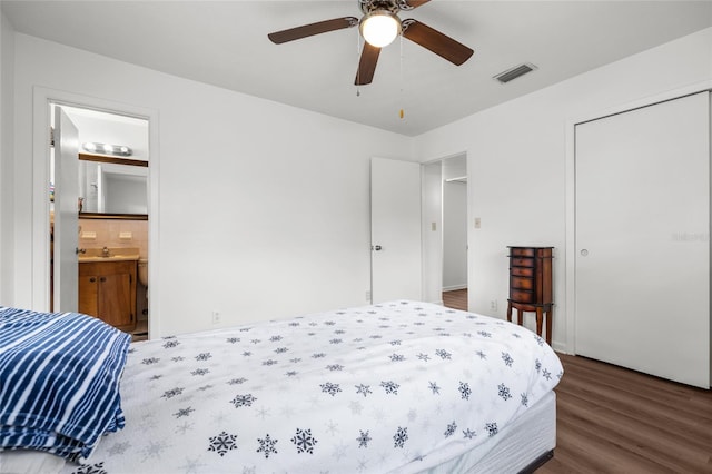 bedroom with dark wood finished floors, a closet, visible vents, a ceiling fan, and a sink