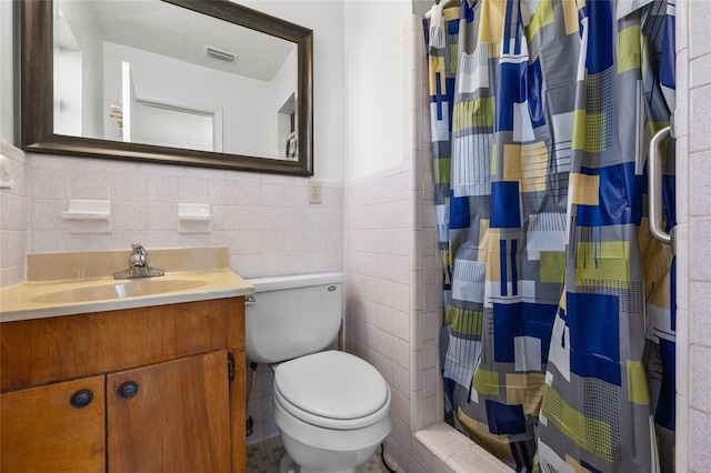 full bathroom featuring toilet, vanity, visible vents, tile walls, and a shower with curtain