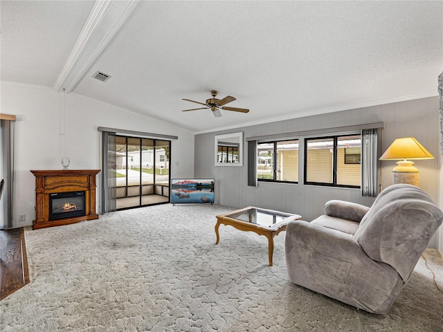 carpeted living room with a glass covered fireplace, visible vents, vaulted ceiling with beams, and a textured ceiling