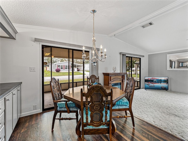 dining room featuring lofted ceiling, a notable chandelier, dark wood-type flooring, visible vents, and crown molding