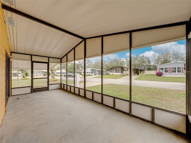 unfurnished sunroom featuring a residential view and vaulted ceiling