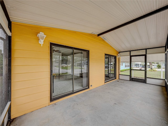 unfurnished sunroom with lofted ceiling with beams