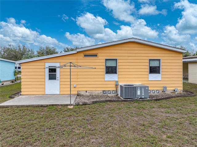 rear view of property with central AC unit, a patio, and a yard