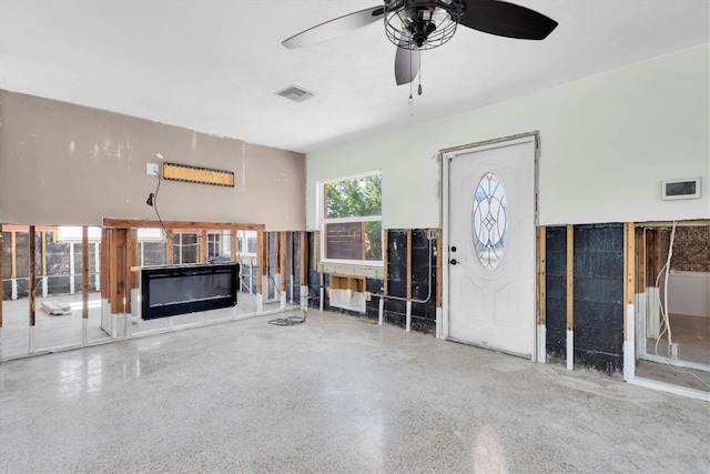 unfurnished living room with ceiling fan, speckled floor, a glass covered fireplace, and visible vents