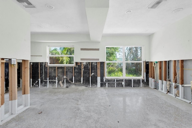 unfurnished living room featuring visible vents and plenty of natural light