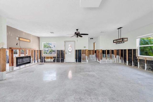 unfurnished living room with a ceiling fan, visible vents, and a multi sided fireplace