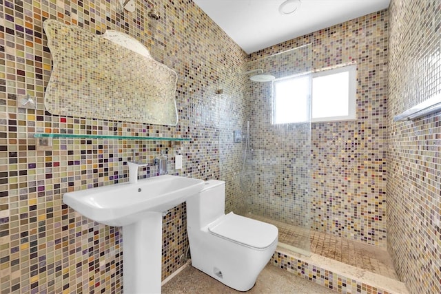 bathroom with a stall shower, a sink, tile walls, and toilet