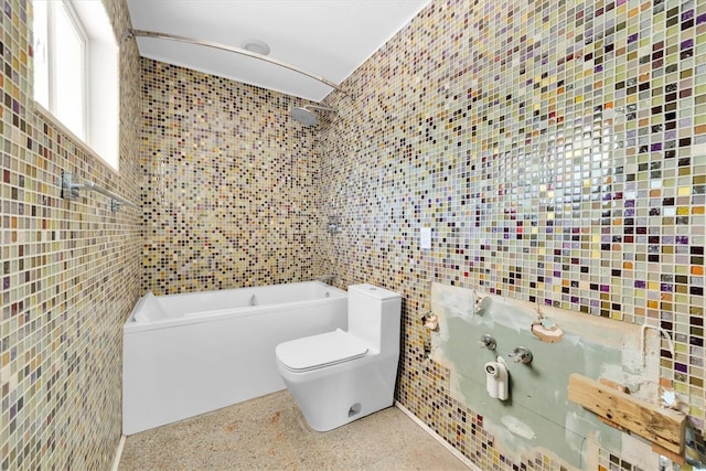 bathroom with toilet, speckled floor, and tile walls