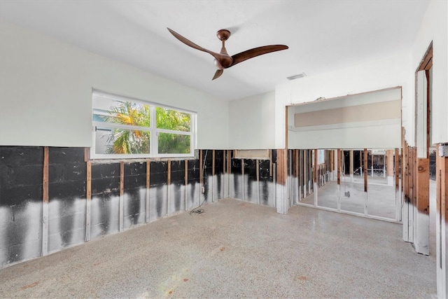 unfurnished room featuring ceiling fan, speckled floor, and visible vents