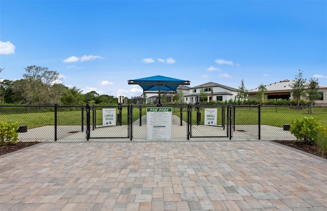 exterior space featuring a gate, fence, and a lawn