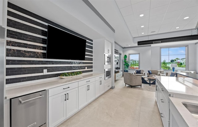 interior space featuring light tile patterned floors, a tray ceiling, a drop ceiling, and recessed lighting