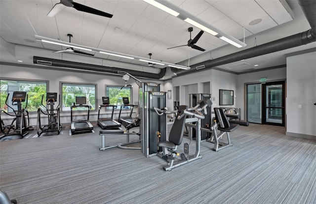 gym with carpet flooring, ceiling fan, a towering ceiling, and baseboards