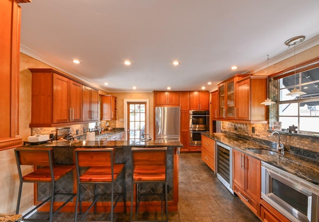 kitchen with wine cooler, glass insert cabinets, appliances with stainless steel finishes, ornamental molding, and a sink