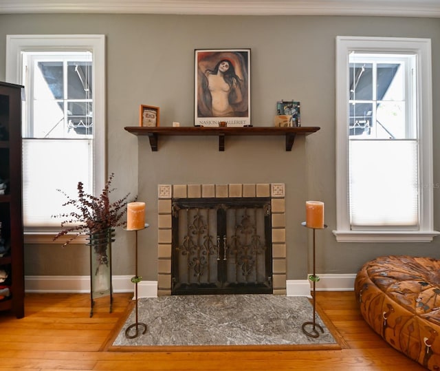 interior space featuring a fireplace with flush hearth, baseboards, and hardwood / wood-style floors