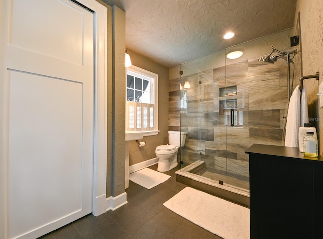 full bath featuring a textured ceiling, a stall shower, toilet, and baseboards