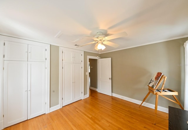 unfurnished bedroom featuring baseboards, ceiling fan, ornamental molding, and light wood-style floors