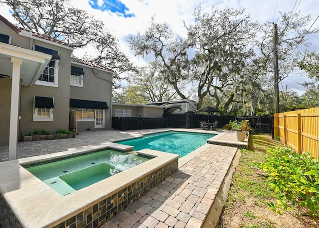 view of swimming pool with a patio area, a fenced backyard, and a pool with connected hot tub