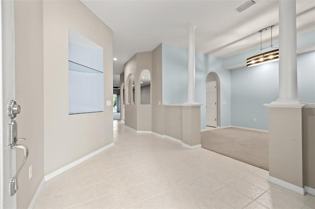 corridor featuring arched walkways, decorative columns, recessed lighting, visible vents, and baseboards