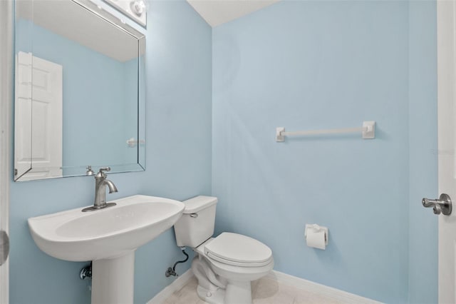 bathroom featuring toilet, tile patterned flooring, and baseboards