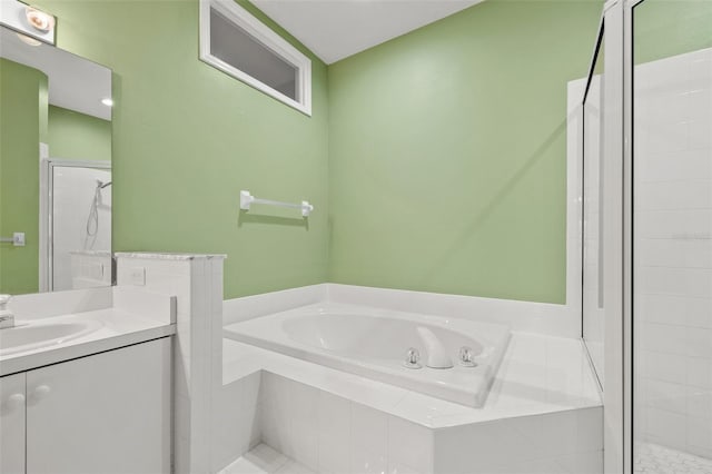 full bathroom featuring a stall shower, a garden tub, and vanity