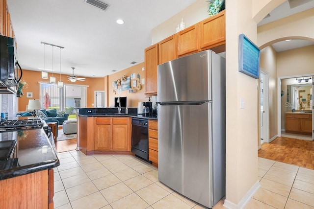 kitchen featuring a peninsula, black appliances, dark countertops, and visible vents