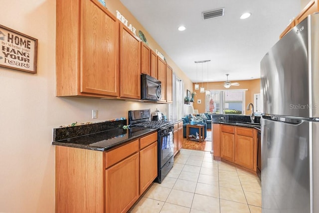 kitchen featuring visible vents, open floor plan, light tile patterned flooring, a sink, and black appliances