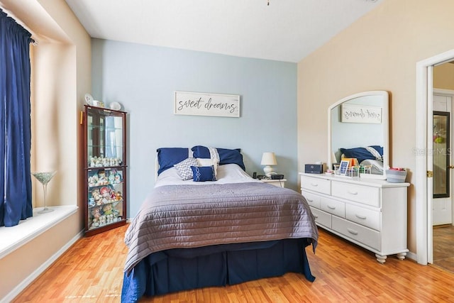 bedroom featuring light wood finished floors and baseboards