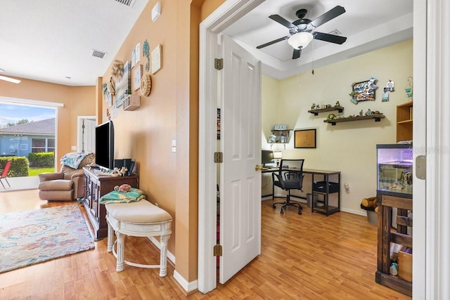 interior space with light wood-style floors, visible vents, baseboards, and a ceiling fan