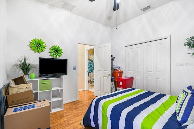 bedroom featuring ceiling fan, a closet, visible vents, and wood finished floors