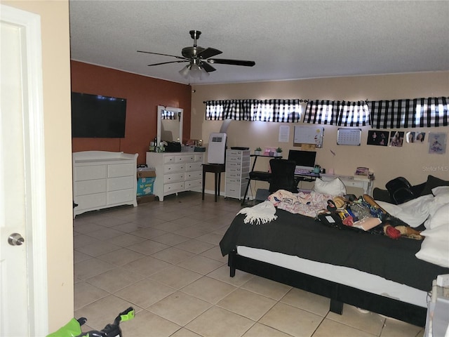 tiled bedroom featuring ceiling fan and a textured ceiling