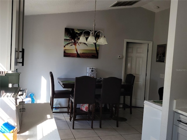 dining area with vaulted ceiling, visible vents, a chandelier, and light tile patterned flooring